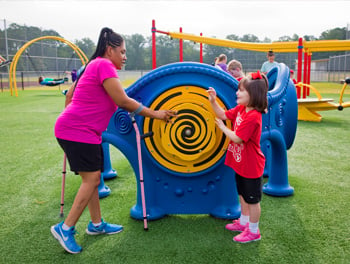 Adult and child playing on inclusive playground with Rain Sound Wheel Panel for all abilities