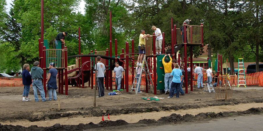 Volunteers building a PlayBooster playground.
