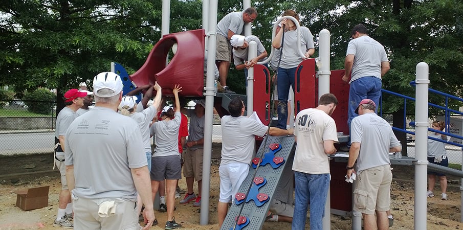 Volunteers build a playground slide.
