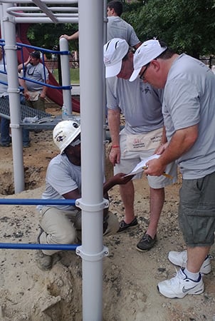 Volunteers looking at playground assembly directions on the playground build site.