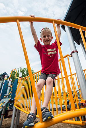 Young boy climbing on a PlayBooster Sky Rail Climber.