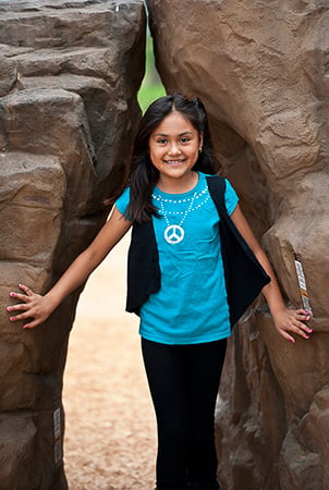 A young girl stands between the Pinnacle and pointe rock climber