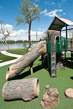 Nature themed playground with log slide and tunnels.