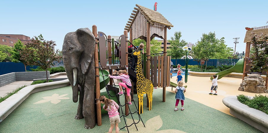 Children playing on a animal themed playground. 