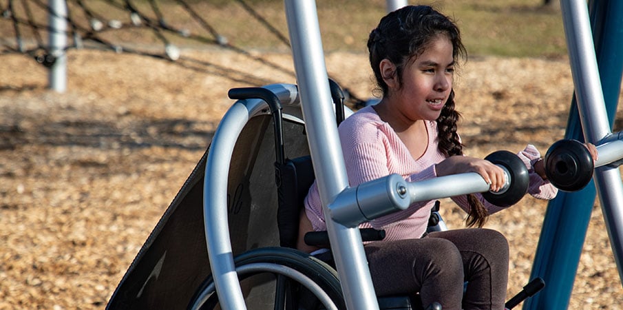 Close up on little girl in We-Go-Swing in wheelchair.