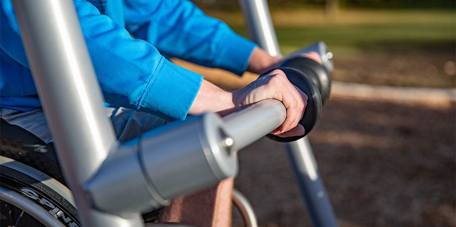 Close-up on child's hands on bar of We-Go-Swing.