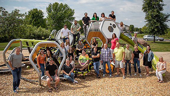 Landscape Structures Design Team posing as a group in front of a playground