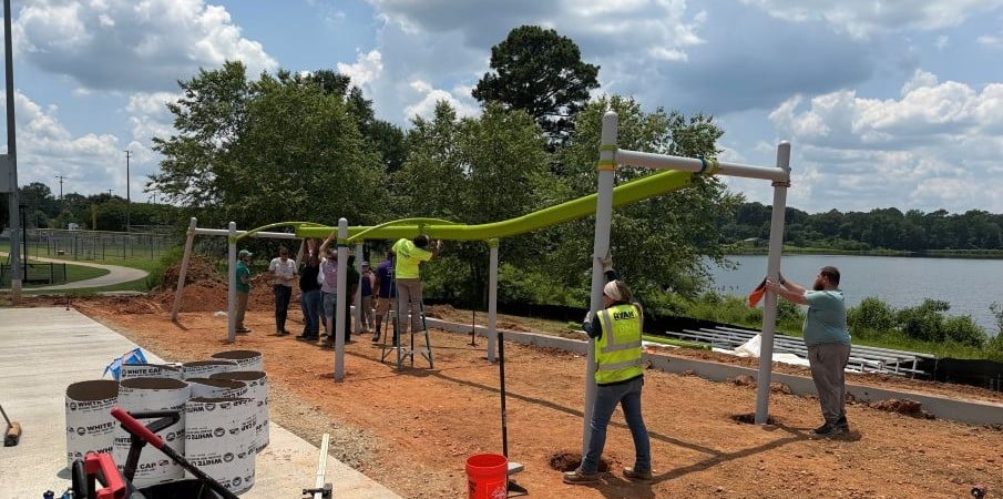 People working together to construct a playground zipline