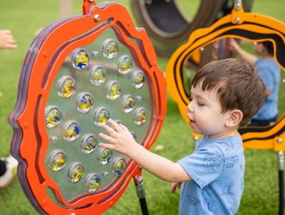 A boy touches a marble panel on a playground