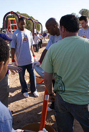 Men listen to one man speak at a Kaboom installation site. 