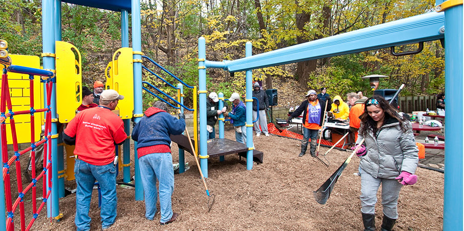 KABOOM! volunteers spreading mulch at a new playground build site.