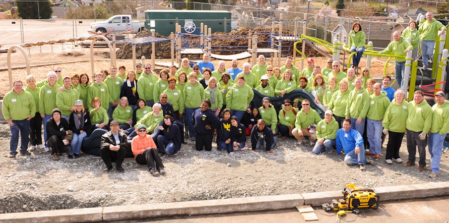 Volunteer playground builders take a  group photo at the build site.