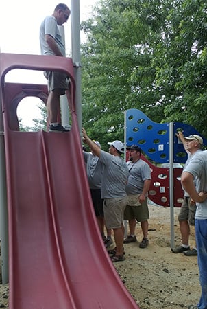 Volunteers attaching a Cascade Climber to a playground.