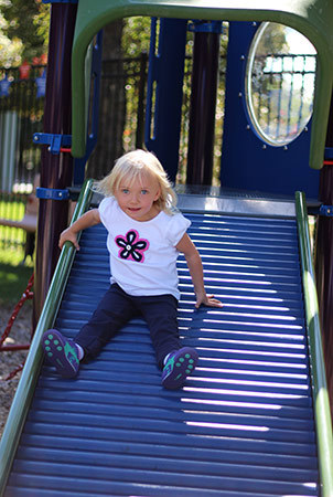 Girl slides down a roller slide. 