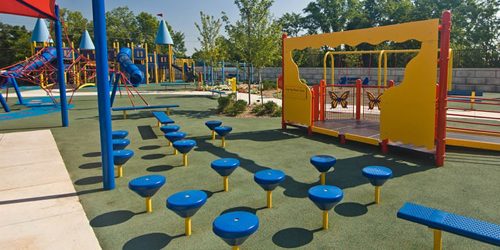 Playground with multiple blue steppers in the foreground. 